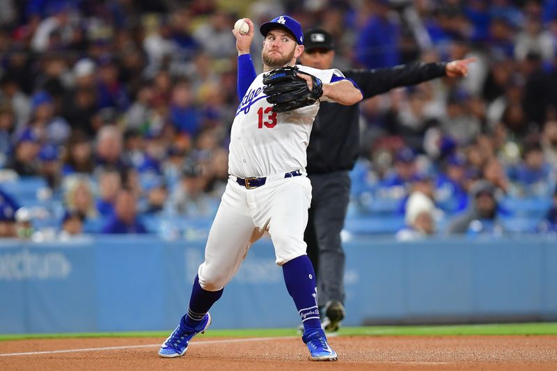 May 4, 2024; Los Angeles, California, USA; Los Angeles Dodgers third baseman Max Muncy (13) throws to first for the out against Atlanta Braves third baseman Austin Riley (27) during the eighth inning at Dodger Stadium. Mandatory Credit: Gary A. Vasquez-USA TODAY Sports