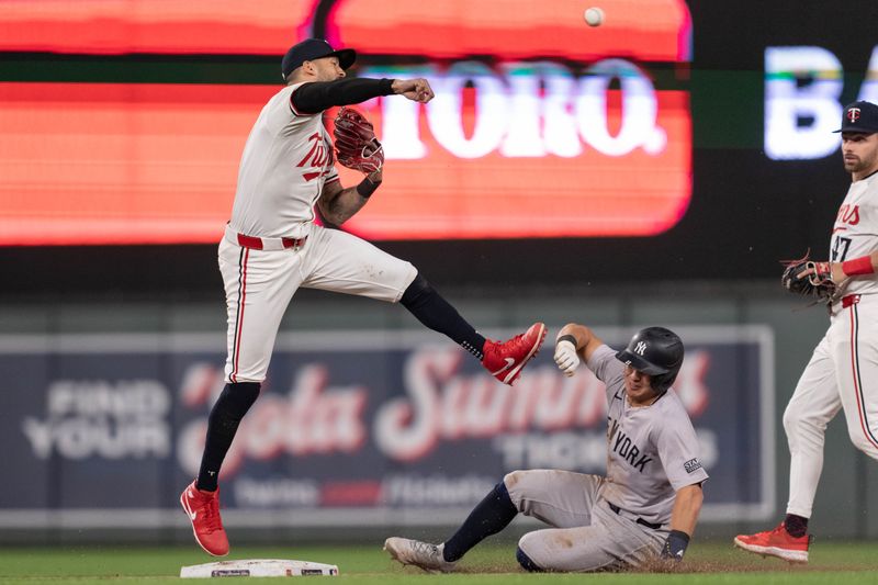 May 15, 2024; Minneapolis, Minnesota, USA; Minnesota Twins shortstop Carlos Correa (4) leaps over New York Yankees shortstop Anthony Volpe (11) to complete the double play on a ball hit by New York Yankees right fielder Juan Soto (22) at Target Field. Mandatory Credit: Matt Blewett-USA TODAY Sports