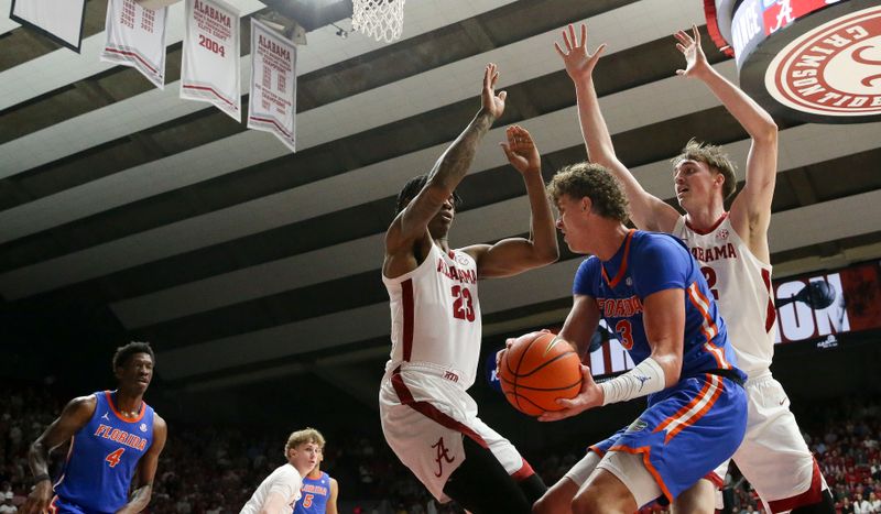 Feb 21, 2024; Tuscaloosa, Alabama, USA;  Alabama Crimson Tide forward Nick Pringle (23) and forward Grant Nelson (2) box in Florida Gators center Micah Handlogten (3) on the baseline at Coleman Coliseum. Mandatory Credit: Gary Cosby Jr.-USA TODAY Sports