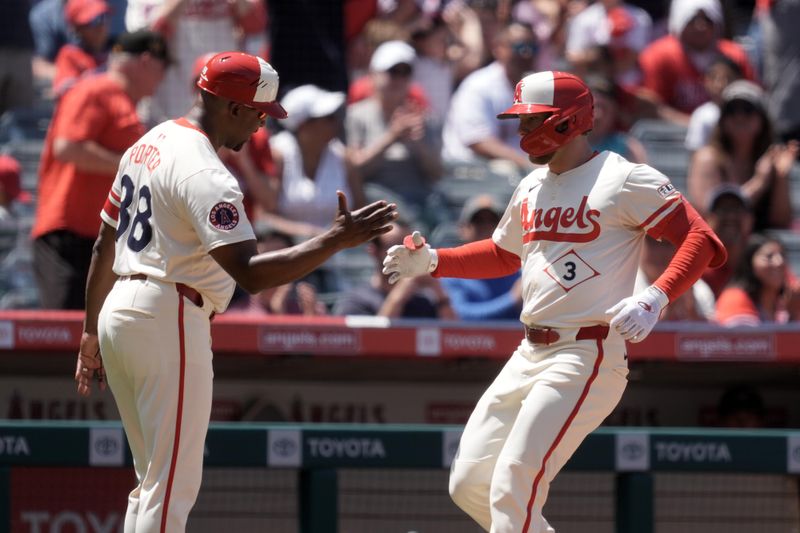 Jun 8, 2025; Anaheim, California, USA; Los Angeles Angels left fielder Taylor Ward (3) is congratulated by third base coach Bo Porter (88) after hitting a two-run home run in the fourth inning against the Seattle Mariners at Angel Stadium. Mandatory Credit: Kirby Lee-Imagn Images