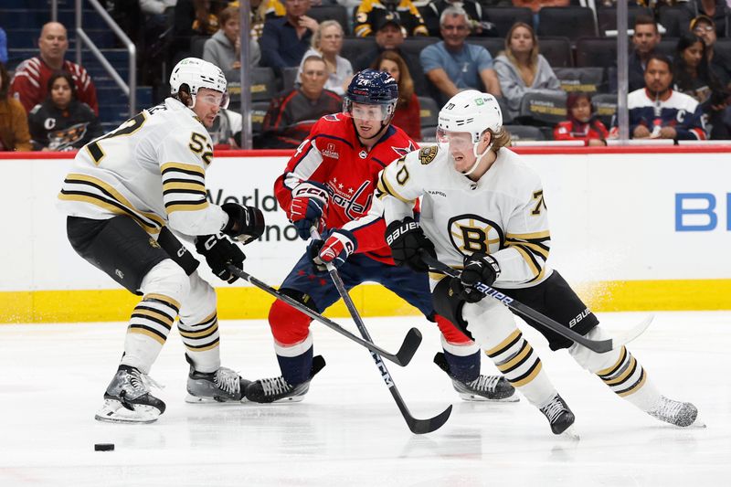 Apr 15, 2024; Washington, District of Columbia, USA; Washington Capitals center Connor McMichael (24) battles for the puck with Boston Bruins center Jesper Boqvist (70) and Bruins defenseman Andrew Peeke (52) in the third period at Capital One Arena. Mandatory Credit: Geoff Burke-USA TODAY Sports