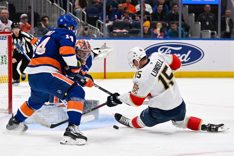 Oct 26, 2024; Elmont, New York, USA;  New York Islanders center Bo Horvat (14) defends against Florida Panthers center Anton Lundell (15) in front of New York Islanders goaltender Semyon Varlamov (40) during the first period at UBS Arena. Mandatory Credit: Dennis Schneidler-Imagn Images