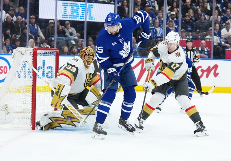 Jan 23, 2026; Toronto, Ontario, CAN; Toronto Maple Leafs center Nicolas Roy (55) battles for the puck with Vegas Golden Knights defenseman Ben Hutton (17) during the first period at Scotiabank Arena. Mandatory Credit: Nick Turchiaro-Imagn Images