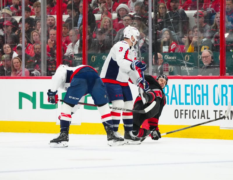 May 10, 2025; Raleigh, North Carolina, USA; Washington Capitals right wing Taylor Raddysh (16) and defenseman Matt Roy (3) checks Carolina Hurricanes center Logan Stankoven (22) during the third period in game three of the second round of the 2025 Stanley Cup Playoffs at Lenovo Center. Mandatory Credit: James Guillory-Imagn Images
