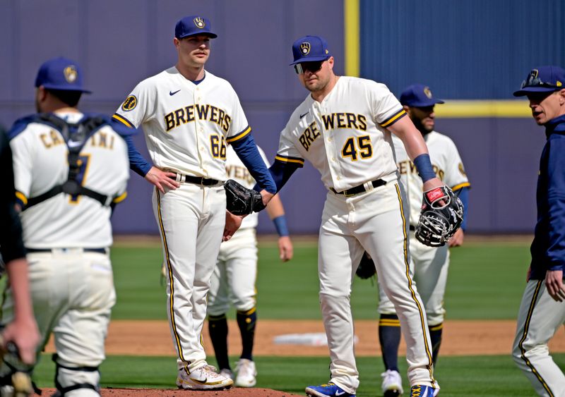 Feb 26, 2023; Phoenix, Arizona, USA;  Milwaukee Brewers starting pitcher Janson Junk (66) is patted by first baseman Luke Voit (45) as he is pulled in the first inning of a spring training game against the Oakland Athletics at American Family Fields of Phoenix. Mandatory Credit: Jayne Kamin-Oncea-USA TODAY Sports