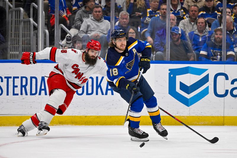 Apr 12, 2024; St. Louis, Missouri, USA;  St. Louis Blues center Robert Thomas (18) passes the puck as Carolina Hurricanes defenseman Brent Burns (8) defends during the third period at Enterprise Center. Mandatory Credit: Jeff Curry-USA TODAY Sports