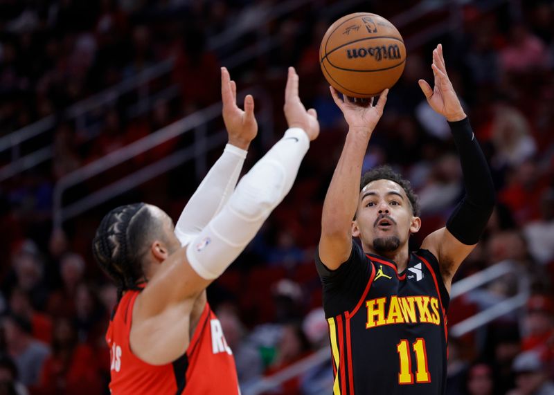 HOUSTON, TEXAS - DECEMBER 20: Trae Young #11 of the Atlanta Hawks shoots over Dillon Brooks #9 of the Houston Rockets during the first half at Toyota Center on December 20, 2023 in Houston, Texas. User expressly acknowledges and agrees that, by downloading and or using this photograph, User is consenting to the terms and conditions of the Getty Images License Agreement.?  (Photo by Carmen Mandato/Getty Images)