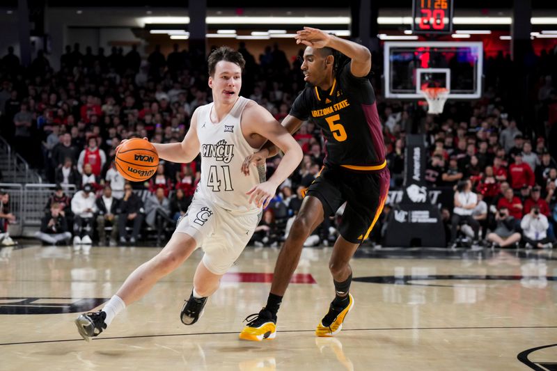 Jan 18, 2025; Cincinnati, Ohio, USA;  Cincinnati Bearcats guard Simas Lukosius (41) dribbles the ball against Arizona State Sun Devils guard Amier Ali (5) in the first half at Fifth Third Arena. Mandatory Credit: Aaron Doster-Imagn Images