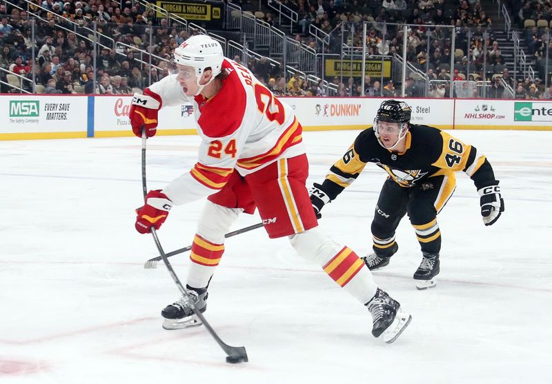 Nov 30, 2024; Pittsburgh, Pennsylvania, USA;  Calgary Flames defenseman Jake Bean (24) shoots the puck ahead of Pittsburgh Penguins center Blake Lizotte (46) during the second period at PPG Paints Arena. Mandatory Credit: Charles LeClaire-Imagn Images