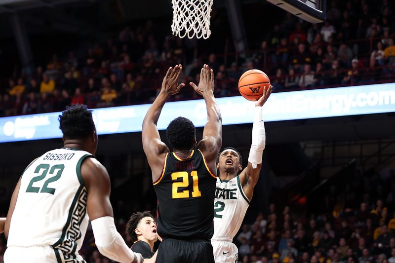 Feb 6, 2024; Minneapolis, Minnesota, USA; Michigan State Spartans guard Tyson Walker (2) shoots as Minnesota Golden Gophers forward Pharrel Payne (21) defends during the second half at Williams Arena. Mandatory Credit: Matt Krohn-USA TODAY Sports