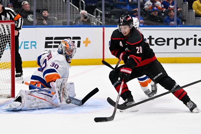 Mar 19, 2024; Elmont, New York, USA; New York Islanders goaltender Ilya Sorokin (30) makes a save on Carolina Hurricanes center Sebastian Aho (20) during the third period at UBS Arena. Mandatory Credit: Dennis Schneidler-USA TODAY Sports