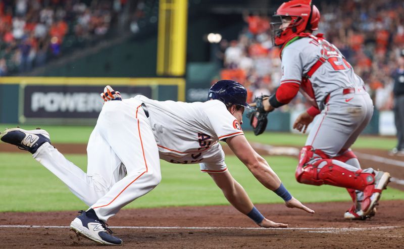 May 22, 2024; Houston, Texas, USA; Houston Astros center fielder Jake Meyers (6) slides past Los Angeles Angels catcher Matt Thaiss (21) to score a run during the fifth inning at Minute Maid Park. Mandatory Credit: Troy Taormina-USA TODAY Sports