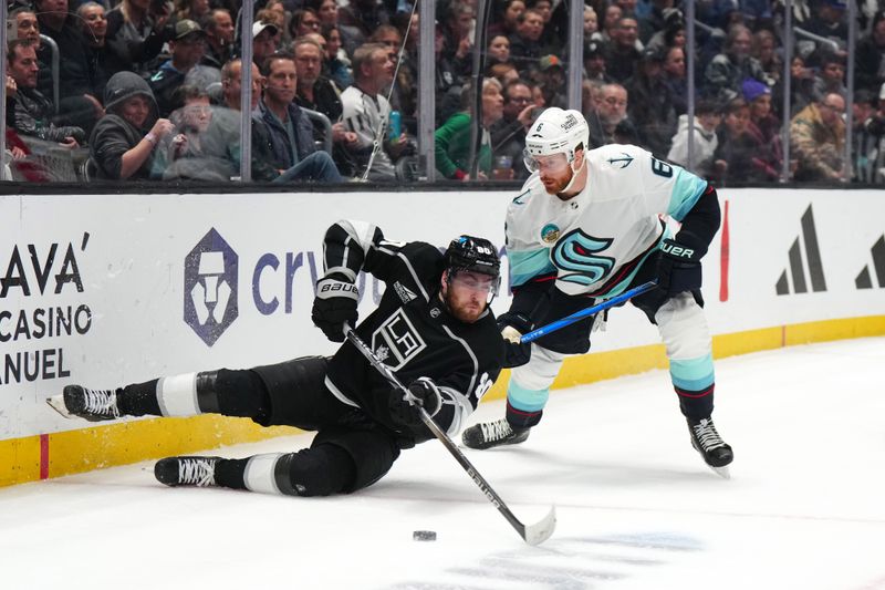 Dec 20, 2023; Los Angeles, California, USA; LA Kings center Pierre-Luc Dubois (80) reaches for the puck against Seattle Kraken defenseman Adam Larsson (6) in the second period at Crypto.com Arena. Mandatory Credit: Kirby Lee-USA TODAY Sports