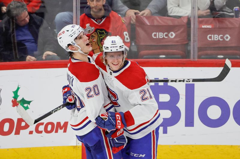 Dec 22, 2023; Chicago, Illinois, USA; Montreal Canadiens left wing Juraj Slafkovsky (20) celebrates with defenseman Kaiden Guhle (21) after scoring against the Chicago Blackhawks during the second period at United Center. Mandatory Credit: Kamil Krzaczynski-USA TODAY Sports