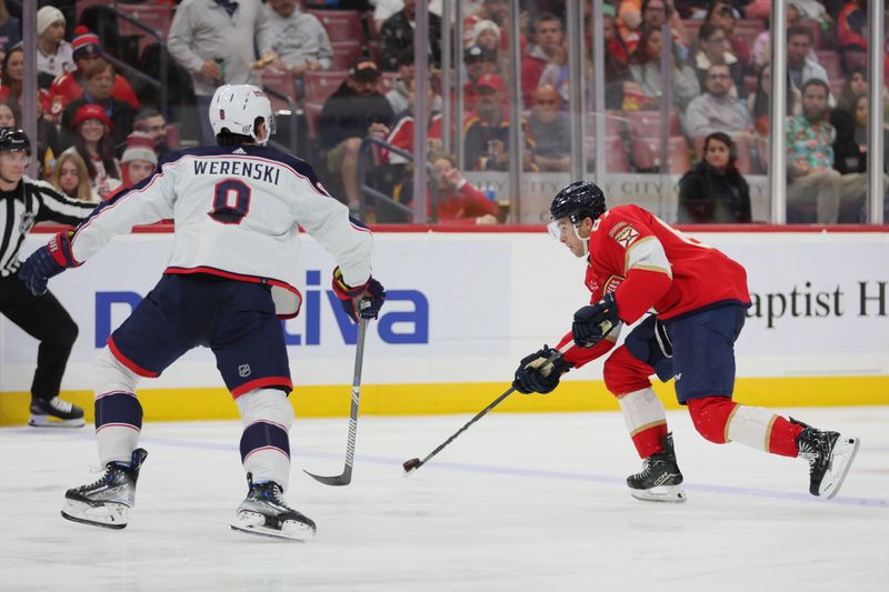 Nov 6, 2023; Sunrise, Florida, USA;  Florida Panthers right wing William Lockwood (67) moves the puck as Columbus Blue Jackets defenseman Zach Werenski (8) defends during the second period at Amerant Bank Arena. Mandatory Credit: Sam Navarro-USA TODAY Sports