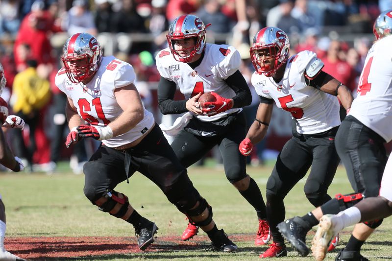 Nov 9, 2019; Fayetteville, AR, USA; Western Kentucky Hilltoppers quarterback Ty Storey (4) rushes between offensive lineman Jordan Meredith (61) and running back Gaej Walker (5) during the game against the Arkansas Razorbacks at Donald W. Reynolds Razorback Stadium. Western Kentucky won 45-19. Mandatory Credit: Nelson Chenault-USA TODAY Sports