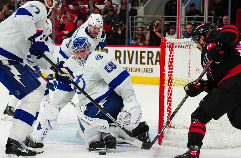 Nov 24, 2023; Raleigh, North Carolina, USA; Tampa Bay Lightning goaltender Andrei Vasilevskiy (88) stops the scoring attempt by Carolina Hurricanes center Seth Jarvis (24) during the first period at PNC Arena. Mandatory Credit: James Guillory-USA TODAY Sports