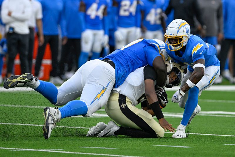 New Orleans Saints quarterback Jameis Winston (2) is tackled by Los Angeles Chargers defensive tackle Christopher Hinton (91) and safety Raheem Layne (41) in the first half of an NFL football game in Inglewood, Calif., Sunday, Aug. 20, 2023. (AP Photo/Alex Gallardo)