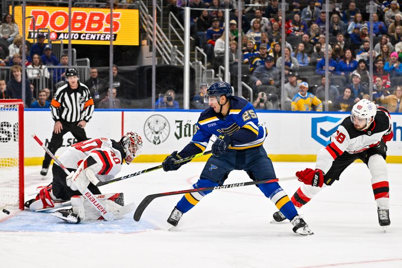 Nov 3, 2023; St. Louis, Missouri, USA;  St. Louis Blues center Jordan Kyrou (25) shoots as New Jersey Devils goaltender Akira Schmid (40) and defenseman Kevin Bahl (88) defend during the third period at Enterprise Center. Mandatory Credit: Jeff Curry-USA TODAY Sports