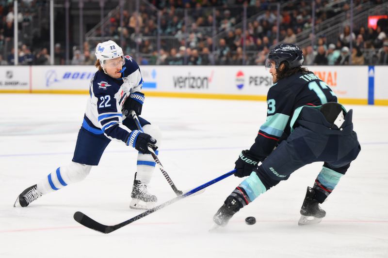 Mar 8, 2024; Seattle, Washington, USA; Winnipeg Jets center Mason Appleton (22) shoots the puck while defended by Seattle Kraken left wing Brandon Tanev (13) during the first period at Climate Pledge Arena. Mandatory Credit: Steven Bisig-USA TODAY Sports