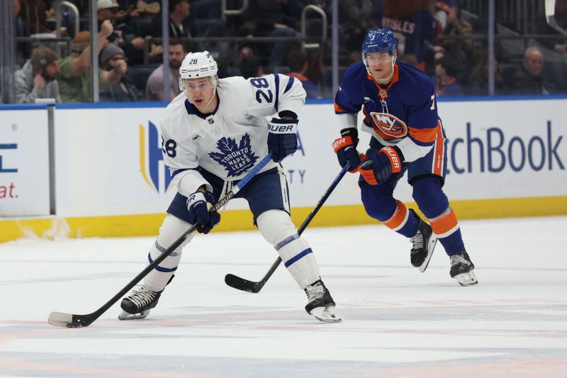 Jan 3, 2026; Elmont, New York, USA; Toronto Maple Leafs defenseman Troy Stecher (28) moves the puck up ice against the New York Islanders during the first period at UBS Arena. Mandatory Credit: Thomas Salus-Imagn Images