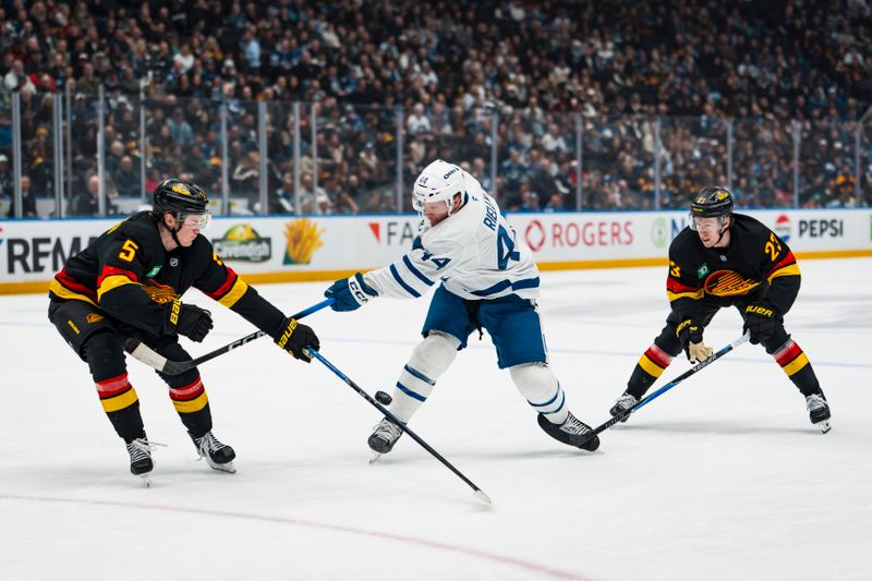 Jan 31, 2026; Vancouver, British Columbia, CAN; Vancouver Canucks forward Jonathan Lekkerimaki (23) watches as defenseman Tom Willander (5) stick checks Toronto Maple Leafs defenseman Morgan Rielly (44) in the first period at Rogers Arena. Mandatory Credit: Bob Frid-Imagn Images