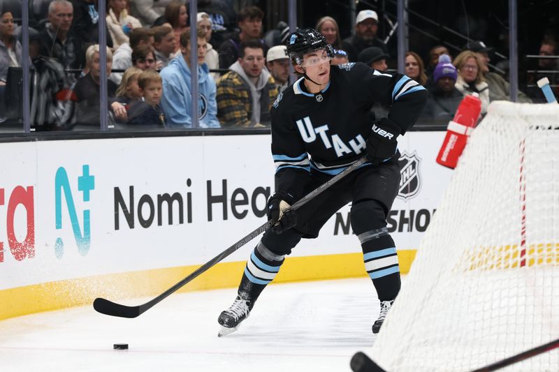 Oct 24, 2024; Salt Lake City, Utah, USA; Utah Hockey Club defenseman Michael Kesselring (7) looks to pass the puck against the Colorado Avalanche during the first period at Delta Center. Mandatory Credit: Rob Gray-Imagn Images