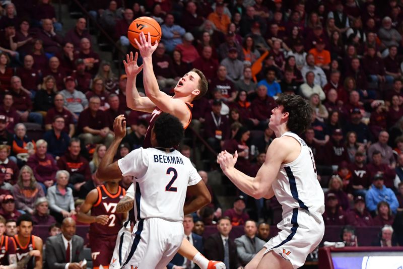 Feb 19, 2024; Blacksburg, Virginia, USA; Virginia Tech Hokies guard Sean Pedulla (3) goes in for a layup while being defended by Virginia Cavaliers guard Reece Beekman (2) and Virginia Cavaliers forward Blake Buchanan (0) during the second half at Cassell Coliseum. Mandatory Credit: Brian Bishop-USA TODAY Sports