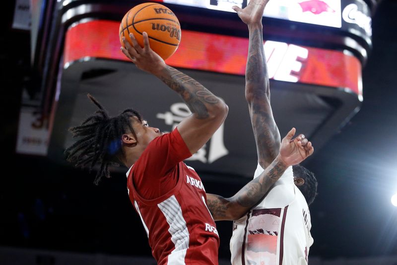 Feb 17, 2024; Starkville, Mississippi, USA; Arkansas Razorbacks guard Khalif Battle (0) shoots the ball against Mississippi State Bulldogs forward Cameron Matthews (4)  during the second half at Humphrey Coliseum. Mandatory Credit: Petre Thomas-USA TODAY Sports