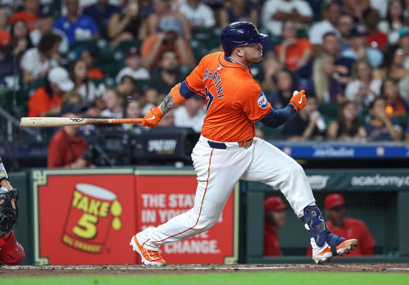 Sep 20, 2024; Houston, Texas, USA; Houston Astros catcher Victor Caratini (17) hits a single during the second inning against the Los Angeles Angels at Minute Maid Park. Mandatory Credit: Troy Taormina-Imagn Images