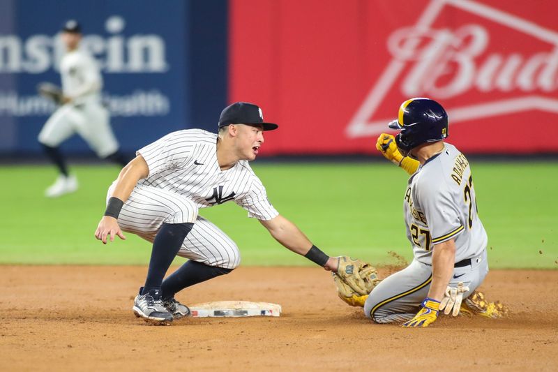 Sep 8, 2023; Bronx, New York, USA;  New York Yankees shortstop Anthony Volpe (11) tries to tag Milwaukee Brewers shortstop Willy Adames (27) at second base in the seventh inning at Yankee Stadium. Mandatory Credit: Wendell Cruz-USA TODAY Sports