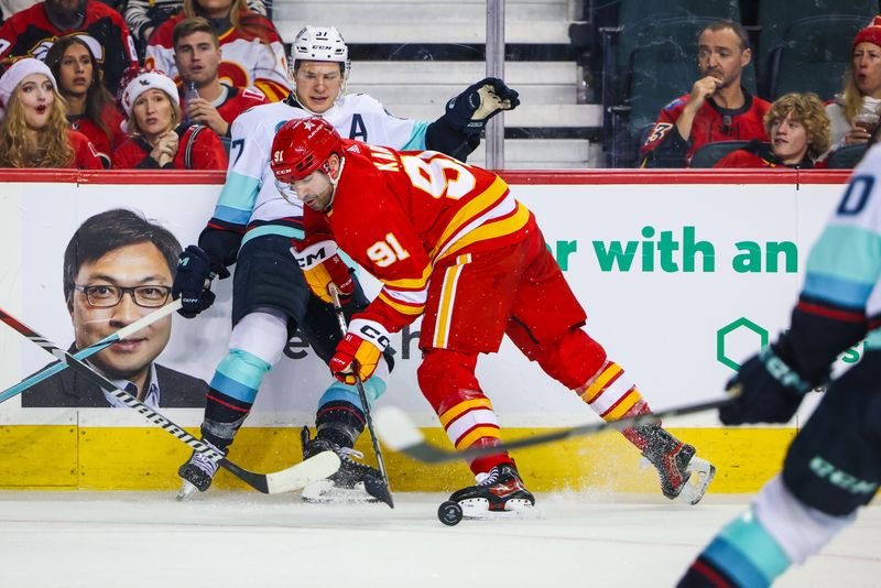 Dec 27, 2023; Calgary, Alberta, CAN; Calgary Flames center Nazem Kadri (91) and Seattle Kraken center Yanni Gourde (37) battle for the puck during the second period at Scotiabank Saddledome. Mandatory Credit: Sergei Belski-USA TODAY Sports