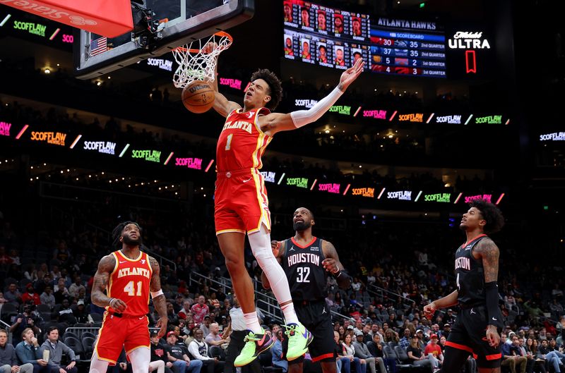 ATLANTA, GEORGIA - FEBRUARY 10:  Jalen Johnson #1 of the Atlanta Hawks dunks against Jeff Green #32 and Jalen Green #4 of the Houston Rockets during the first quarter at State Farm Arena on February 10, 2024 in Atlanta, Georgia.  NOTE TO USER: User expressly acknowledges and agrees that, by downloading and/or using this photograph, user is consenting to the terms and conditions of the Getty Images License Agreement.  (Photo by Kevin C. Cox/Getty Images)