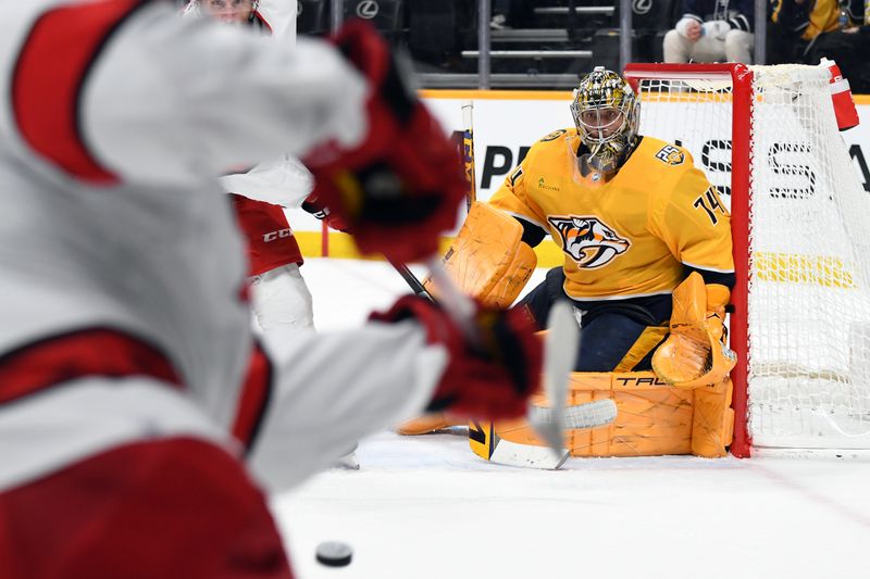 Dec 27, 2023; Nashville, Tennessee, USA; Nashville Predators goaltender Juuse Saros (74) blocks a shot by Carolina Hurricanes left wing Teuvo Teravainen (86) during the second period at Bridgestone Arena. Mandatory Credit: Christopher Hanewinckel-USA TODAY Sports