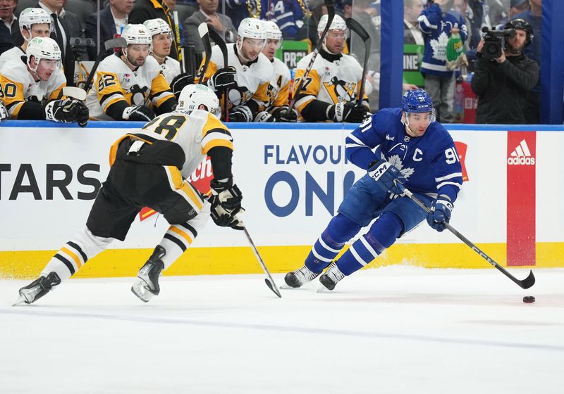 Apr 8, 2024; Toronto, Ontario, CAN; Toronto Maple Leafs center John Tavares (91) controls the puck as Pittsburgh Penguins defenseman Marcus Pettersson (28) tries to defend during the first period at Scotiabank Arena. Mandatory Credit: Nick Turchiaro-USA TODAY Sports