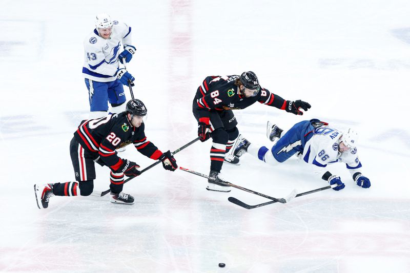 Jan 23, 2026; Chicago, Illinois, USA; Chicago Blackhawks center Ryan Greene (20) and left wing Landon Slaggert (84) defend against Tampa Bay Lightning right wing Nikita Kucherov (86) during the second period at United Center. Mandatory Credit: Kamil Krzaczynski-Imagn Images