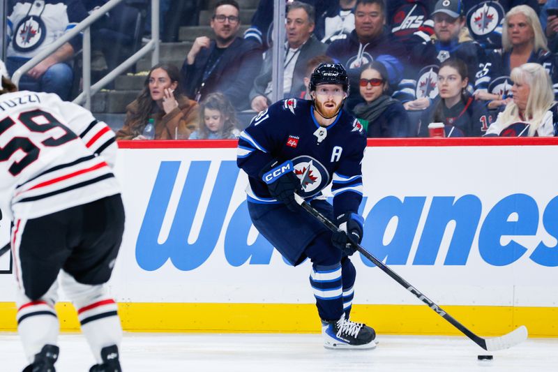 Oct 30, 2025; Winnipeg, Manitoba, CAN;  Winnipeg Jets forward Kyle Connor (81) skates in on Chicago Blackhawks forward Tyler Bertuzzi (59) during the second period at Canada Life Centre. Mandatory Credit: Terrence Lee-Imagn Images