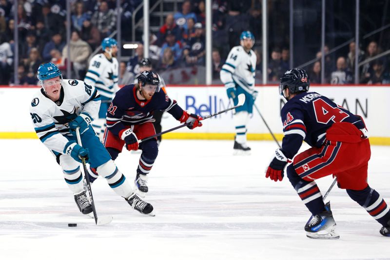 Feb 14, 2024; Winnipeg, Manitoba, CAN; San Jose Sharks left wing Fabian Zetterlund (20) skates through the neutral zone towards Winnipeg Jets defenseman Josh Morrissey (44) in the first period at Canada Life Centre. Mandatory Credit: James Carey Lauder-USA TODAY Sports