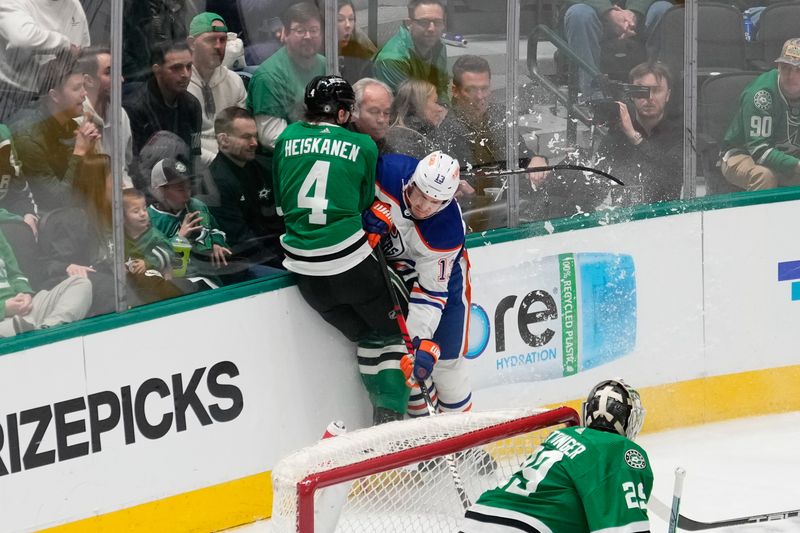 Feb 17, 2024; Dallas, Texas, USA; Dallas Stars defenseman Miro Heiskanen (4) is checked by Edmonton Oilers center Mattias Janmark (13) during the third period at American Airlines Center. Mandatory Credit: Chris Jones-USA TODAY Sports