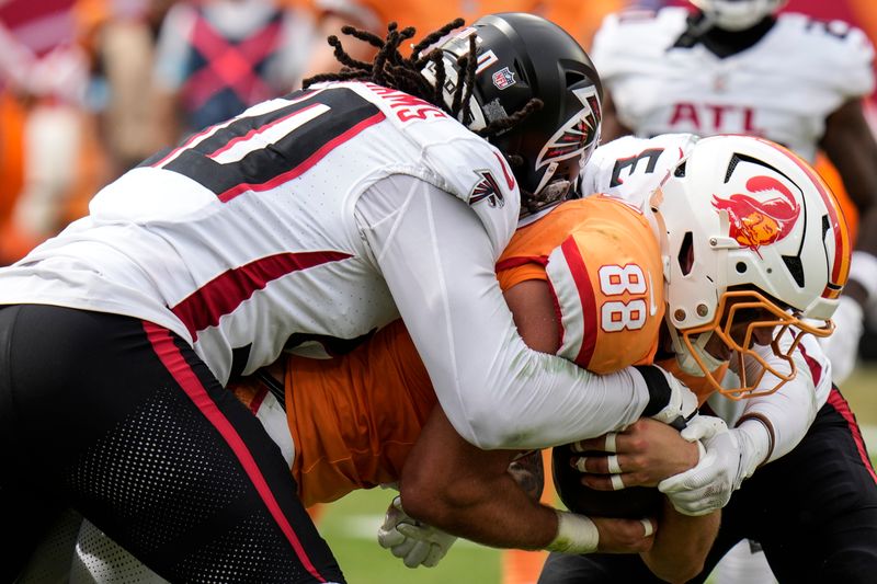 Tampa Bay Buccaneers tight end Cade Otton (88) is stopped by Atlanta Falcons defensive end James Smith-Williams (50) during the first half of an NFL football game, Sunday, Oct. 27, 2024, in Tampa. (AP Photo/Chris O'Meara)