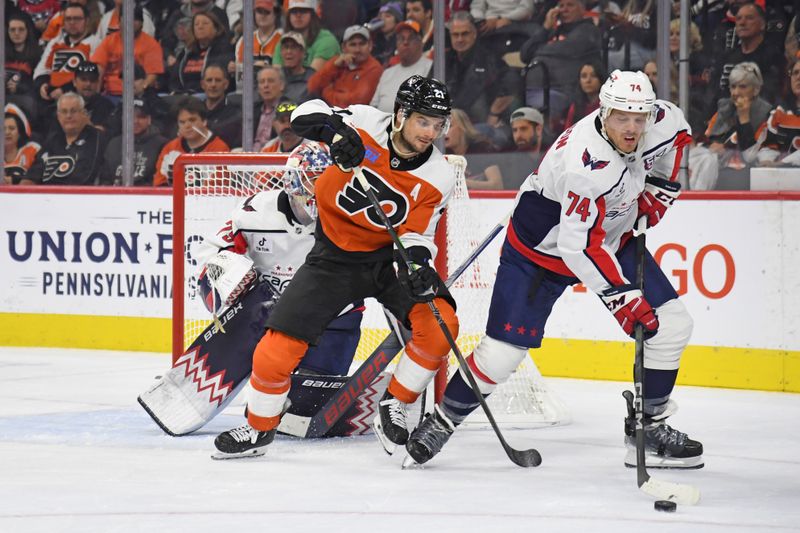 Oct 22, 2024; Philadelphia, Pennsylvania, USA; Washington Capitals defenseman John Carlson (74) clears the puck away from Philadelphia Flyers center Scott Laughton (21) during the second period at Wells Fargo Center. Mandatory Credit: Eric Hartline-Imagn Images