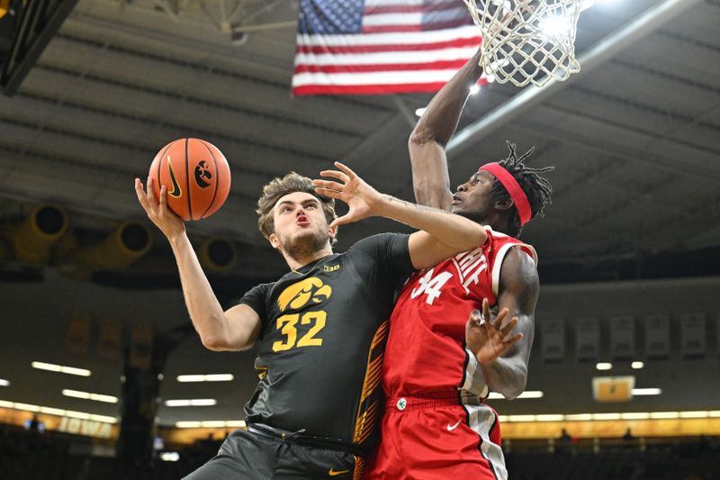 Feb 2, 2024; Iowa City, Iowa, USA; Iowa Hawkeyes forward Owen Freeman (32) goes to the basket as Ohio State Buckeyes center Felix Okpara (34) defends during the second half at Carver-Hawkeye Arena. Mandatory Credit: Jeffrey Becker-USA TODAY Sports