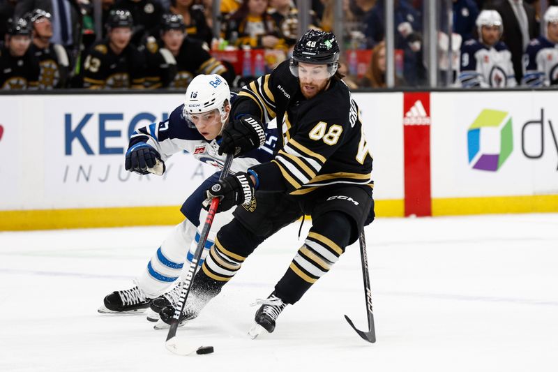 Jan 22, 2024; Boston, Massachusetts, USA; Boston Bruins defenseman Matt Grzelcyk (48) tries to get away from Winnipeg Jets center Rasmus Kupari (15) during the first period at TD Garden. Mandatory Credit: Winslow Townson-USA TODAY Sports