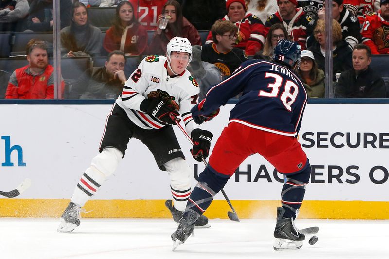 Feb 4, 2026; Columbus, Ohio, USA; Chicago Blackhawks defenseman Alex Vlasic (72) shoots on goal as Columbus Blue Jackets center Boone Jenner (38) defends during the first period at Nationwide Arena. Mandatory Credit: Russell LaBounty-Imagn Images