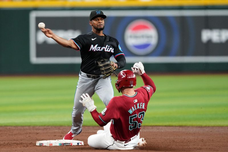 May 25, 2024; Phoenix, Arizona, USA; Miami Marlins second base Otto Lopez (61) throws to first base after forcing out Arizona Diamondbacks first base Christian Walker (53) at second base  during the fourth inning at Chase Field. Mandatory Credit: Joe Camporeale-USA TODAY Sports