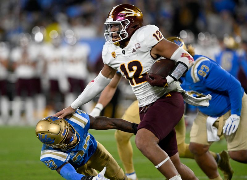 Nov 11, 2023; Pasadena, California, USA;  Arizona State Sun Devils tight end Jalin Conyers (12) pushes away UCLA Bruins defensive back Kenny Churchwell III (23) on a run during the first half at the Rose Bowl. Mandatory Credit: Alex Gallardo-USA TODAY Sports