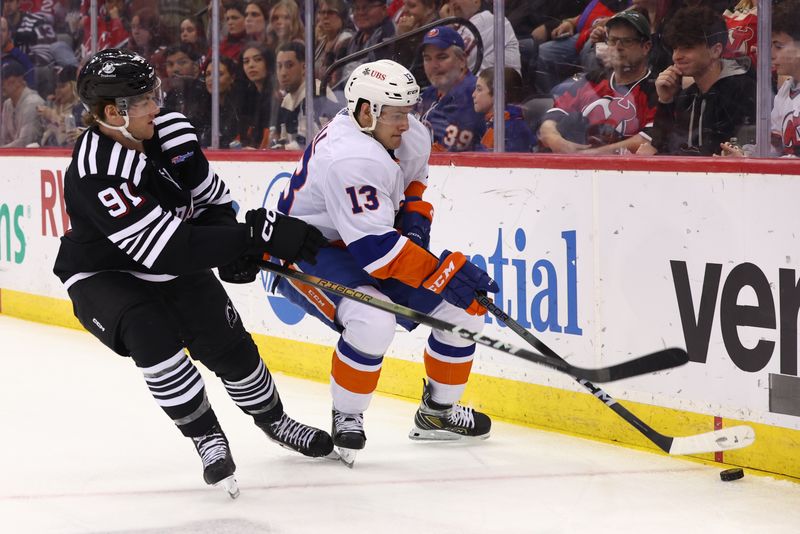 Apr 15, 2024; Newark, New Jersey, USA; New York Islanders center Mathew Barzal (13) plays the puck while being defended by New Jersey Devils center Dawson Mercer (91) during the second period at Prudential Center. Mandatory Credit: Ed Mulholland-USA TODAY Sports