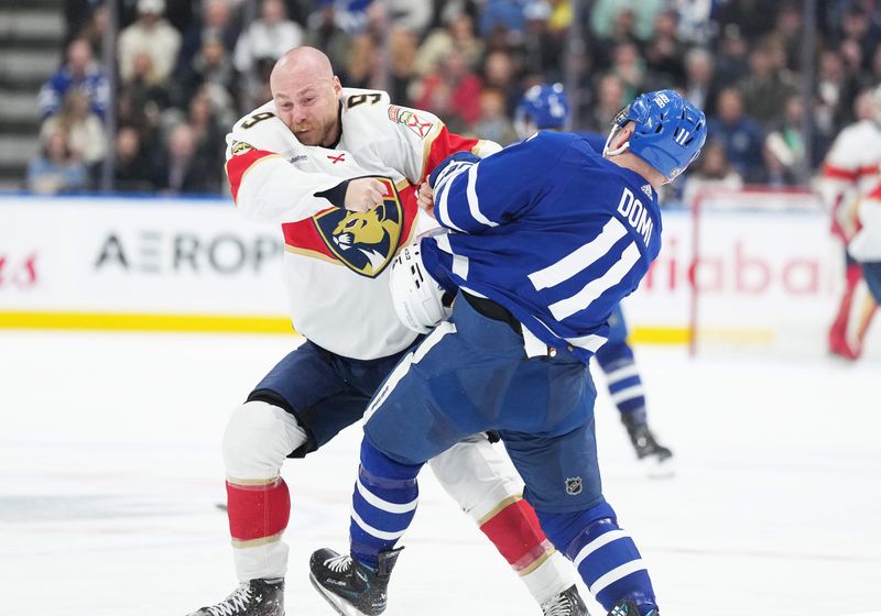 Nov 28, 2023; Toronto, Ontario, CAN; Florida Panthers center Sam Bennett (9) fights with Toronto Maple Leafs center Max Domi (11) during the second period at Scotiabank Arena. Mandatory Credit: Nick Turchiaro-USA TODAY Sports