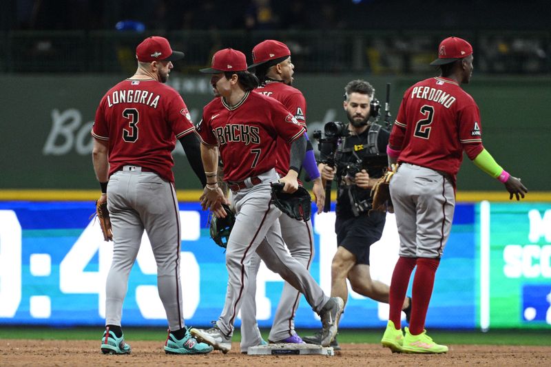 Oct 3, 2023; Milwaukee, Wisconsin, USA; Arizona Diamondbacks third baseman Evan Longoria (3) and left fielder Corbin Carroll (7) celebrate with teammates after defeating the Milwaukee Brewers in game one of the Wildcard series for the 2023 MLB playoffs at American Family Field. Mandatory Credit: Michael McLoone-USA TODAY Sports