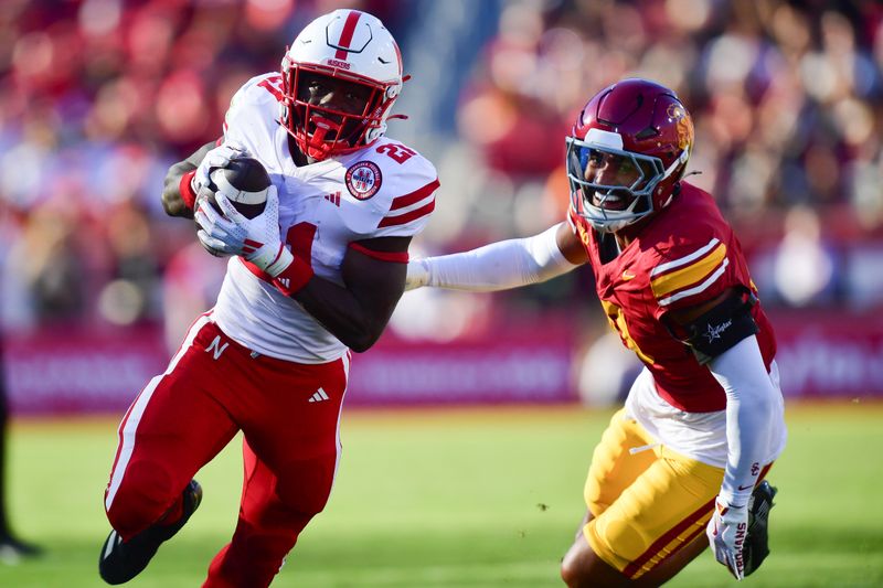 Nov 16, 2024; Los Angeles, California, USA; Nebraska Cornhuskers running back Emmett Johnson (21) runs the ball for a touchdown against the Southern California Trojans during the first half at the Los Angeles Memorial Coliseum. Mandatory Credit: Gary A. Vasquez-Imagn Images